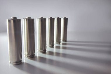 Beyaz arkaplanda bir sırada birçok gri pil sıralanmış