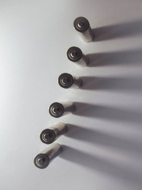 Beyaz arkaplanda bir sırada birçok gri pil sıralanmış