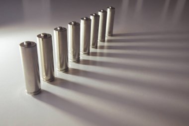 Beyaz arkaplanda bir sırada birçok gri pil sıralanmış