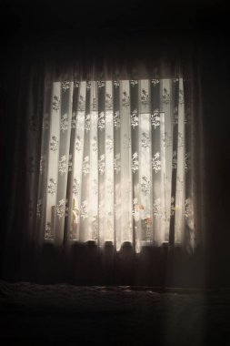 Sabah ışığı pencereden süzülüyor, odadan sızıyor çiçekler perdenin dokusunu vurguluyor.