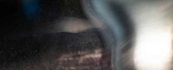 Маленькие капли воды, избитые солнцем в контр-jour форме серых абстракций
