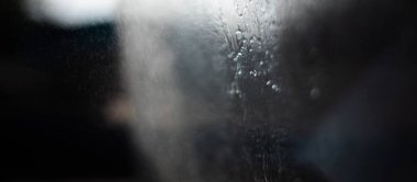 Güneş tarafından dövülen küçük su damlaları gri soyutlamalar oluşturur.