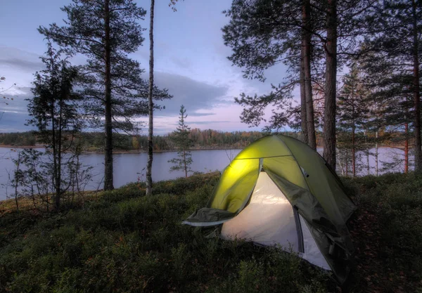 Туристическая палатка в лесу на берегу озера Стоковое Фото