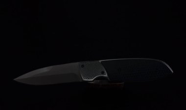 Siyah arka planda izole edilmiş modern katlanabilir cep çakısı.