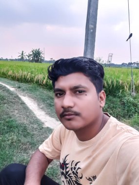 Yeşil tarım alanında oturan Hint köylüleri ve yeşil arka plan, güzel çevre.