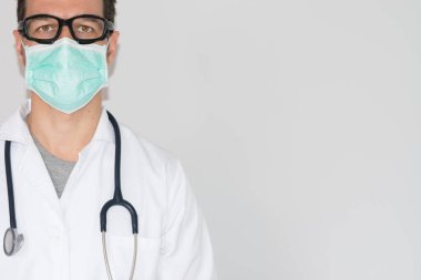 Maskeli ve gözlüklü doktor izole edilmiş beyaz arka planda ve mesaj için yeri var. Sağlık, tıp eğitimi, acil sağlık hizmeti ve cerrahi konsepti.