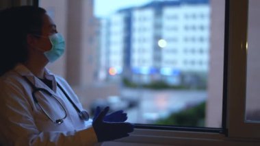 Kadın doktor, koronavirüs yüzünden izole edilmiş insanları alkışlıyor. Bu, her öğleden sonra İspanya 'da başlayan bir dayanışma hareketi. Hastalıkla mücadele eden doktor ve hemşirelere teşekkür etmek için..