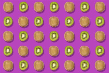 Mor bir arka planda renkli bir kesik ve tüm kivi deseni. Zenital üst görünüm.