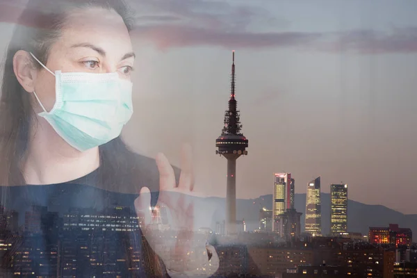 The double exposure of a woman with a mask with famous buildings of the city of Madrid in the back. Concept of primary prevention of diseases such as coronavirus. Concept of confinement and social distancing.