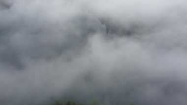 Bulutların üzerinden uç, aşağıdaki zar zor görünen göl ile.