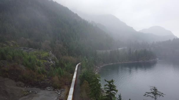 Güterzug Wartet Mit Waldbergen Und Dem Fluss Der Nähe — Stockvideo