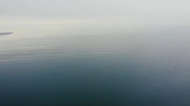 Sakin suyla birlikte ufukta deniz kayboluyor.