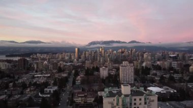 Vancouver 'ın küçük bulutlar ve görünen dağlarla açılış sahnesi.
