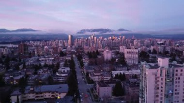 Renkli günbatımında Vancouver mahallesinin üzerinden şehir merkezine doğru uç
