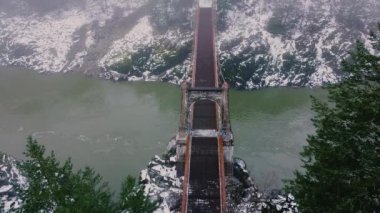 Eski paslı köprüyle yavaşça akan nehrin yukarıdan aşağıya bakan manzarası.