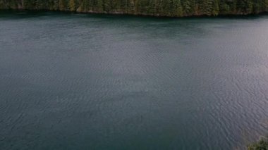 Rüzgarlı bir günde göl manzarası, suda küçük dalgalanmalar.