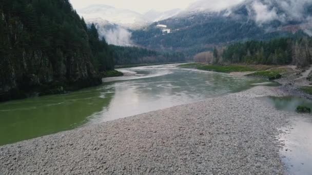 在空中俯瞰卵石和河流 以及周围的群山 云彩和绿林 — 图库视频影像