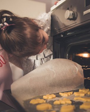 Anne ve küçük kız mutfakta lezzetli yemekler pişiriyorlar.