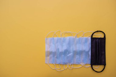 Sarı arka planda farklı bir tıbbi maske