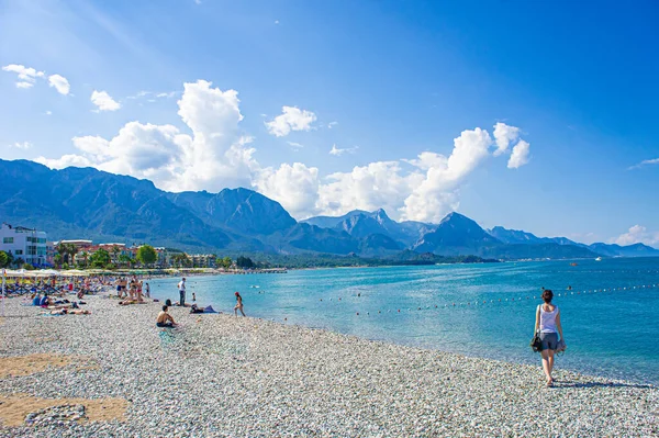 Kız, dağlar, deniz ve kayalık plaj
