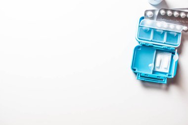 Beyaz masadaki paketlerde farklı ilaç hapları.