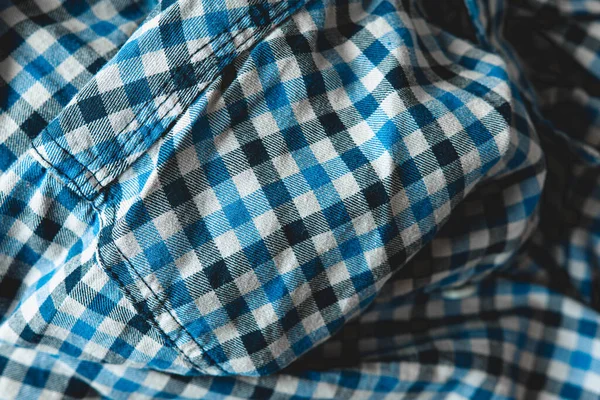 Flannel shirt seamless tartan pattern of blue, grey, black and white fashion clothing. Checked lumber jack shirt material, close up top view of fashionable cloth design, empty cotton fabric