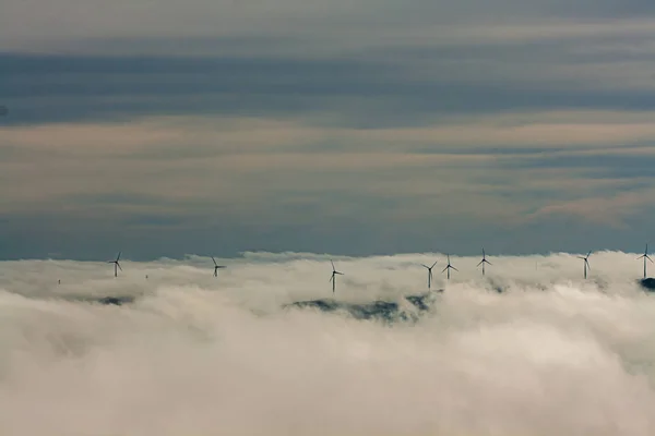 Landscape with wind turbines emerging from the fog in Portugal