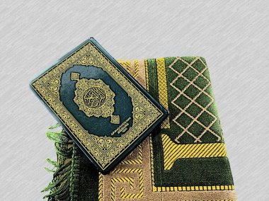 Kuran 'ın resimli resimleri ve Ramazan ayı için dua halıları hazır. Kapaktaki Arapça Kuran olarak tercüme edilir.