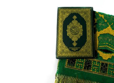 Endonezya 'da. 20 Nisan 2020. Kuran 'ın fotoğrafları ve dua halıları Ramazan ayı için hazır. Kapaktaki Arapça Kuran olarak tercüme edilir.