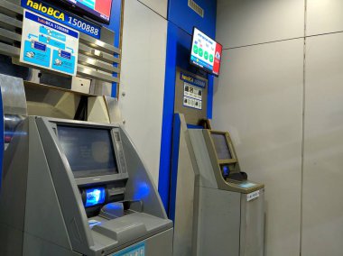 Arka planda modern ATM makineleri