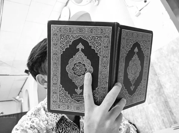 インドネシア 2020年4月20日 ラマダーンの準備ができているコーランを読む男の写真のイラスト 表紙のアラビア語はアラビア語を含むコーランのスーラです — ストック写真