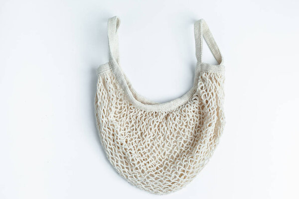 Reusable shopping bag on white background isolate. Ecological concept. Top view of mesh shopping cotton bag. Caring for the environment and the rejection of plastic.