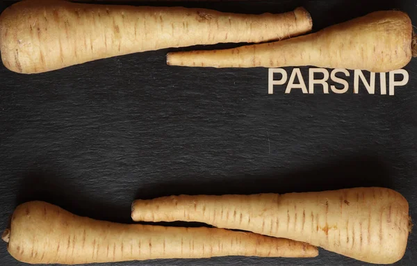 Photography of parsnip on slate background for menus; labels or signs