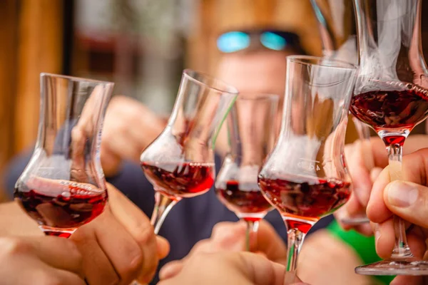 People clink glasses with red alcohol shots on a celebration