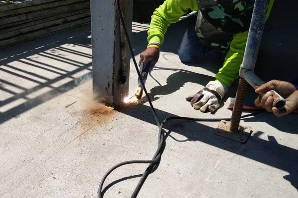 Trabajador de la construcción cortando columna de acero por soldadora — Foto de Stock