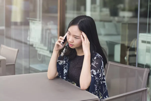 Asiatisk kvinna är allvarligt när du ringer affären fodrar av smartphone — Stockfoto