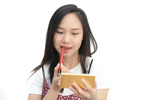 Азиатка наносит красную помаду с косметическим карандашом на Ли — стоковое фото