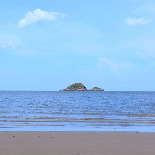 Petite île au milieu de la mer contre le ciel bleu comme fond — Photo