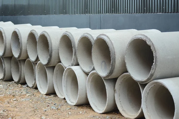 Tubo de drenagem de betão empilhado no local de construção — Fotografia de Stock