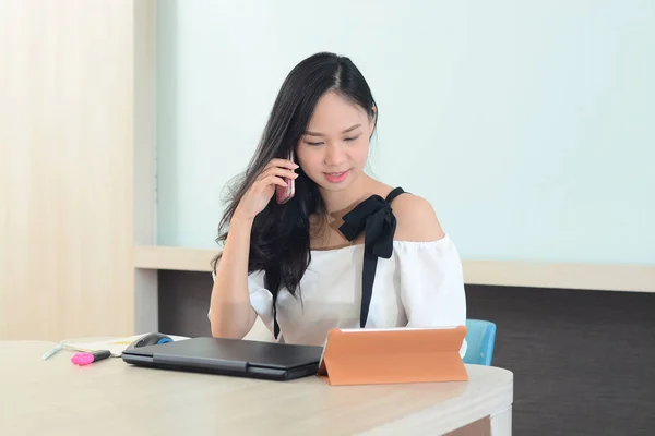 Unga asiatiska företagsledare som arbetar i office anropande custome — Stockfoto