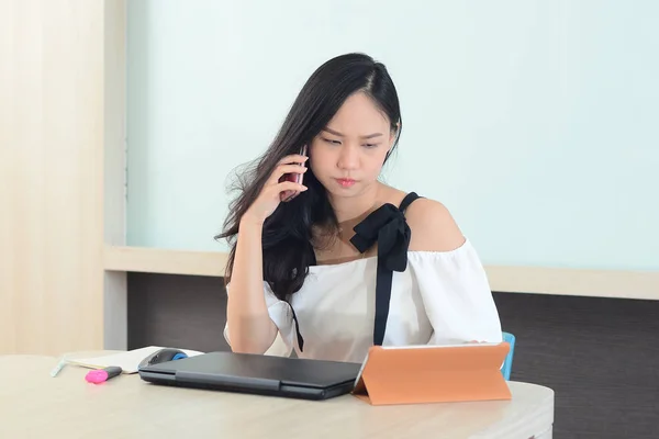 Unga asiatiska företagsledare som arbetar i office anropande custome — Stockfoto