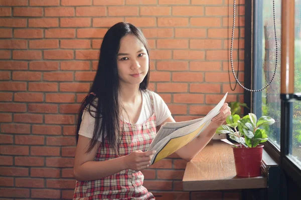 Asiática mujer leyendo periódico en oficina como fondo — Foto de Stock