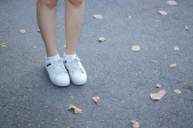 çorak yaprak ile sokakta Ayakkabı ve bacaklar arka plan olarak stand