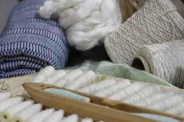 Ahşap tepside çiğ pamuk ipliği ve pamuk kumaşı.