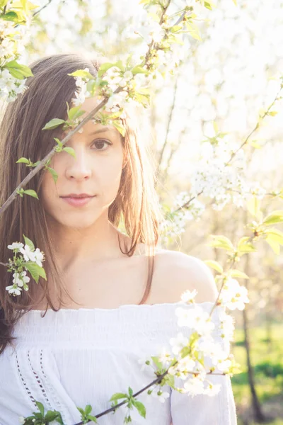 Menina morena bonita desfrutar de um jardim de primavera com flor — Fotografia de Stock