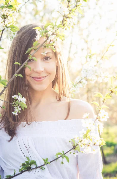 Menina morena bonita desfrutar de um jardim de primavera com flor — Fotografia de Stock