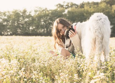 Köpek ile altın sahada oturan kadın