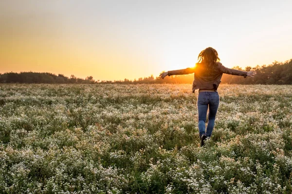 Young woman sun into the sunset on a field — Stock Photo, Image