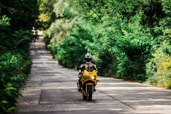 Motorradfahrerin Mit Gelbem Motorrad Stockfoto