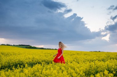 Fırtınadan önce kolza tohumu tarlasında güzel sarışın model